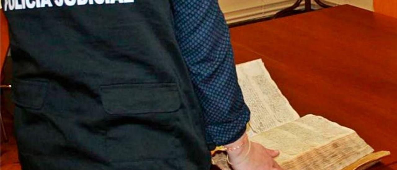 Una agente repasa uno de los manuscritos robados.  | LEVANTE-EMV