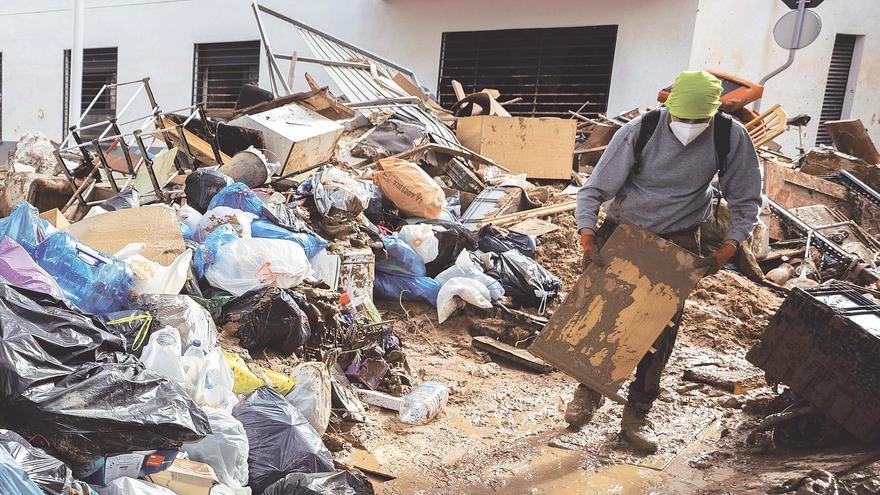 Un hombre, rodeado de escombros, en Paiporta