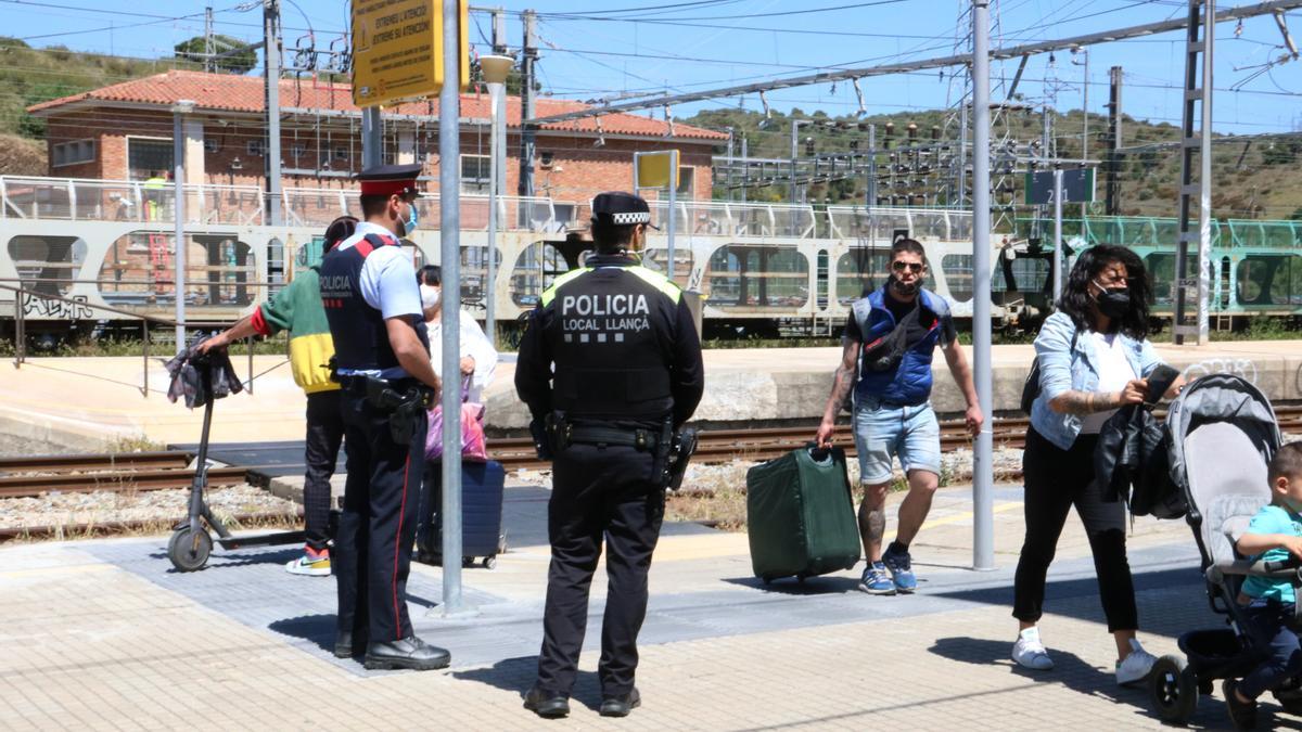 Dos agents dels Mossos i la Policia Local fent un control a l'estació de Llançà