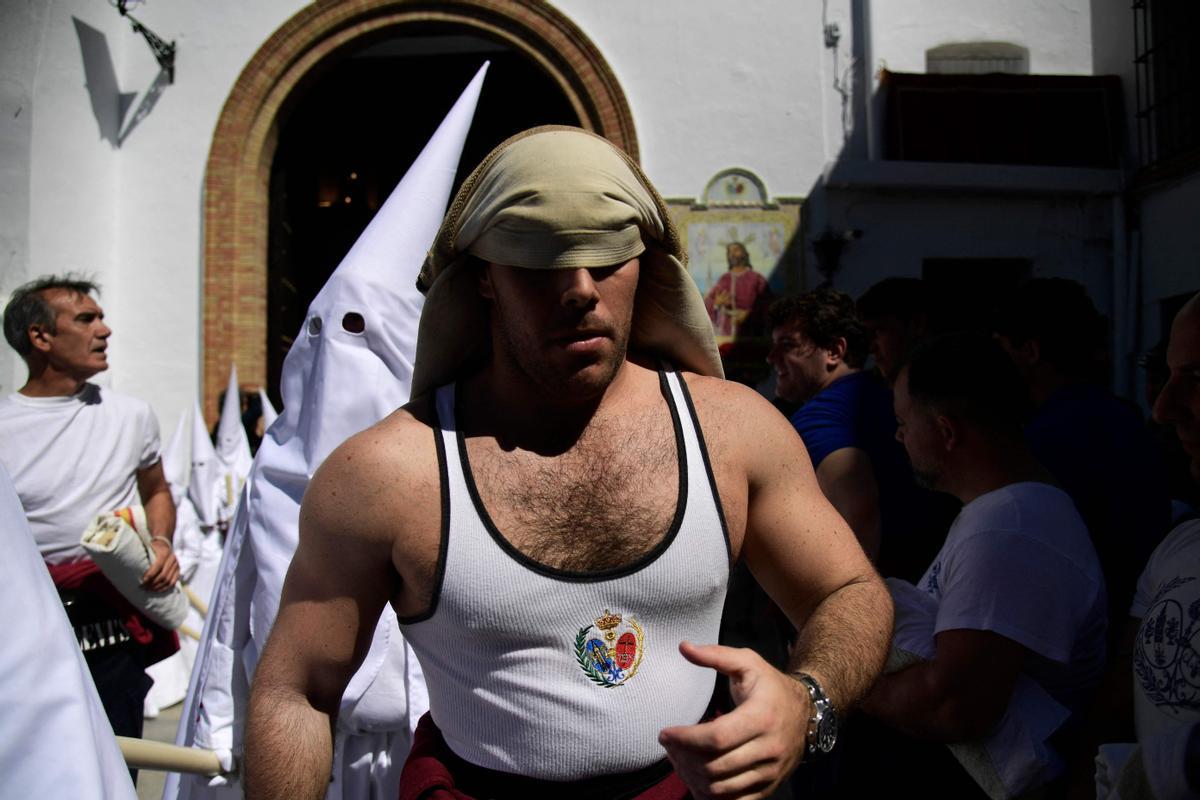 Penitentes de la hermandad de La Paz participan en la procesión del Domingo de Ramos en Sevilla