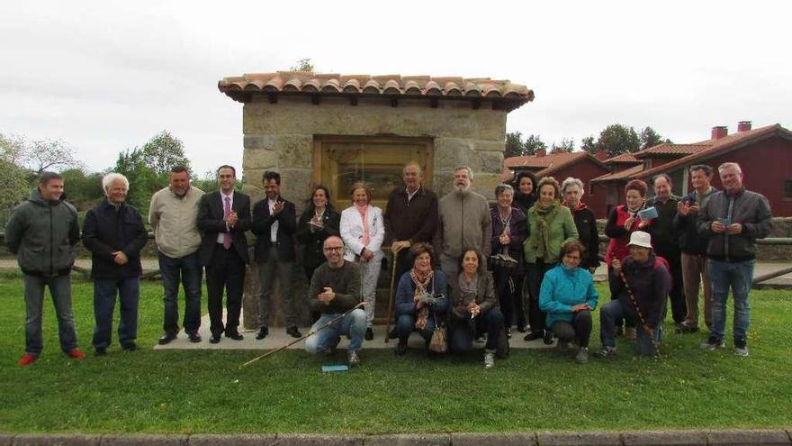 Vecinos del concejo ante la puerta de madera donde se inicia la ruta en Noriega.