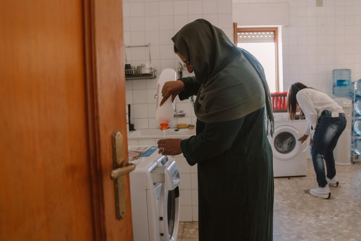Una de las residentes del centro de acogida de Villafranca de los Caballeros poniendo la lavadora