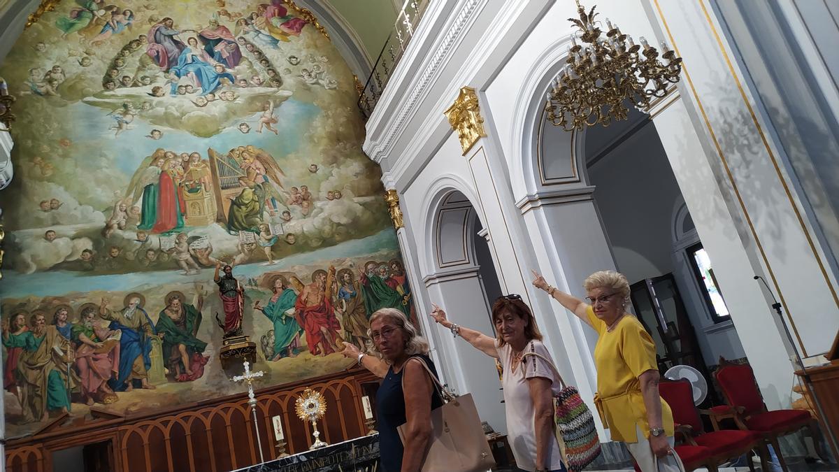 Las hermanas Casar y M. C. Alonso señalan el mural donde están pintadas como angelitos