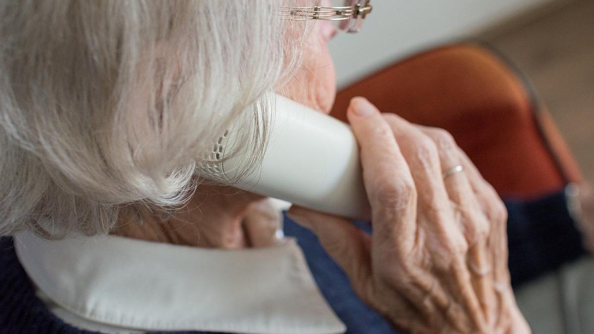 Una anciana habla por teléfono.