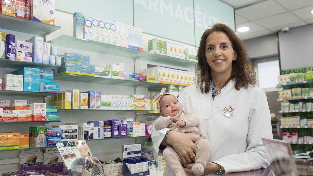 Xènia Planas amb la seva filla petita, a la farmàcia que regenta a Caldes de Malavella.