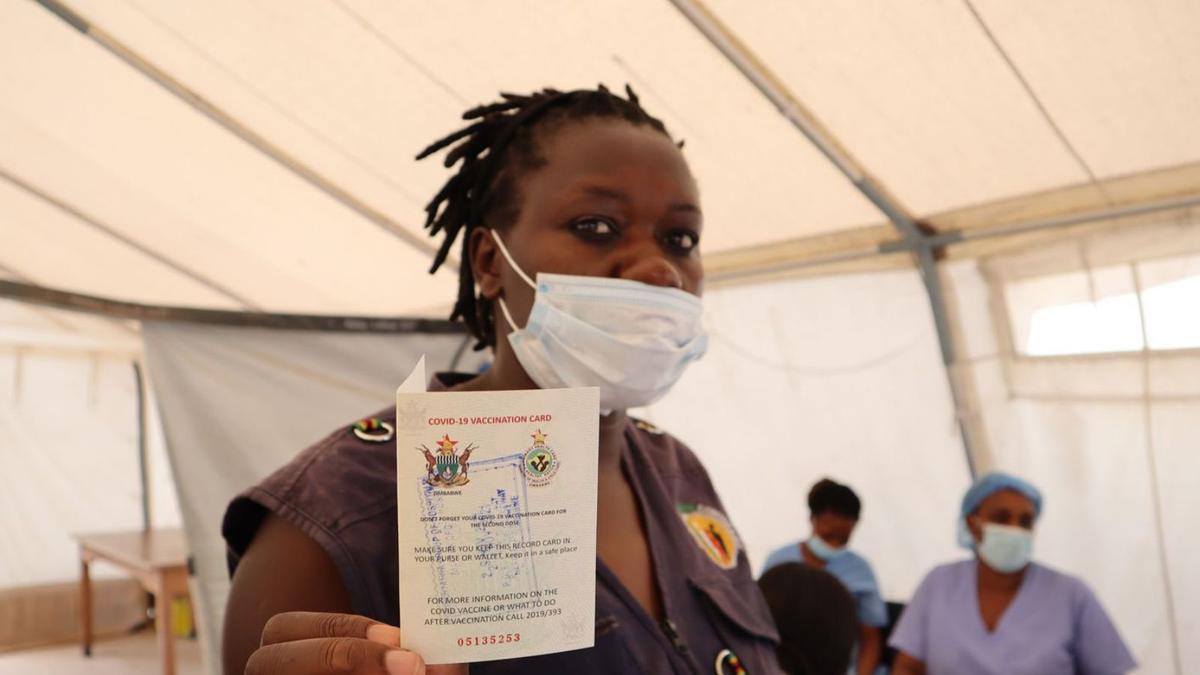 Una mujer muestra su certificado de vacunación en la capital de Zimbabue, Harare, ayer.