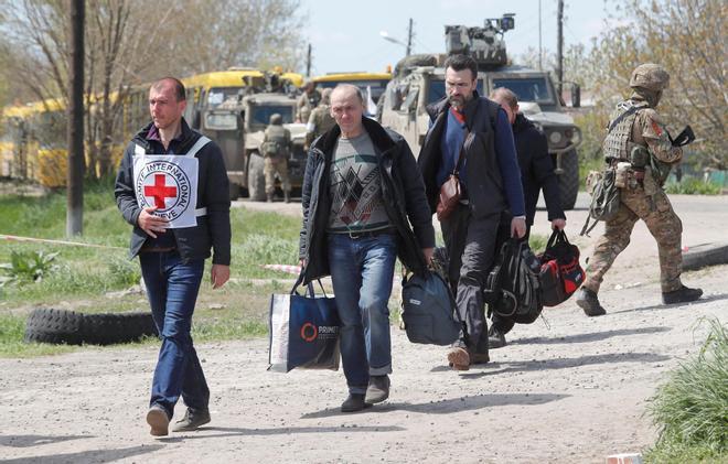 Civilians who left the area near Azovstal steel plant in Mariupol walk at a temporary accommodation centre in Bezimenne