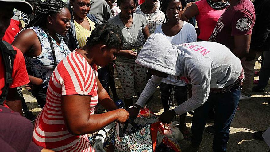 Afectats esperen per rebre menjar a Los Cayos, a Haití. | REUTERS