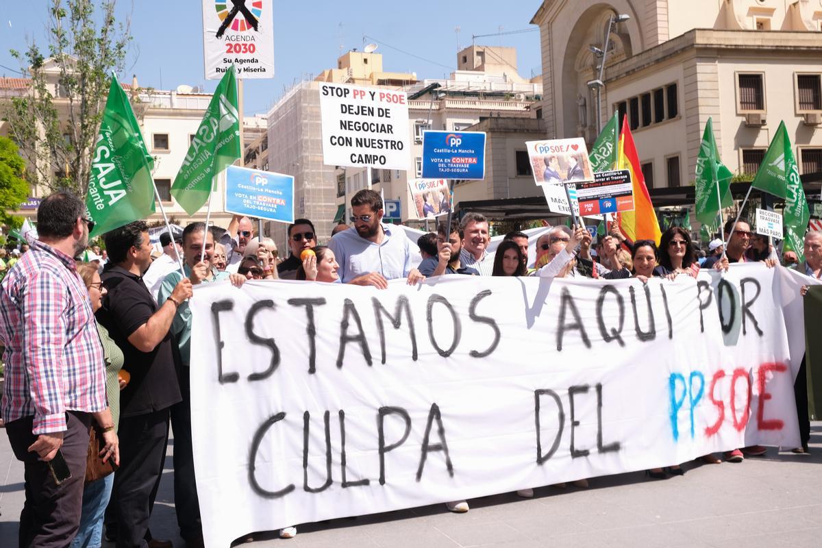 Miembros de Vox sostienen una pancarta contra el PP y el PSOE en la protesta.