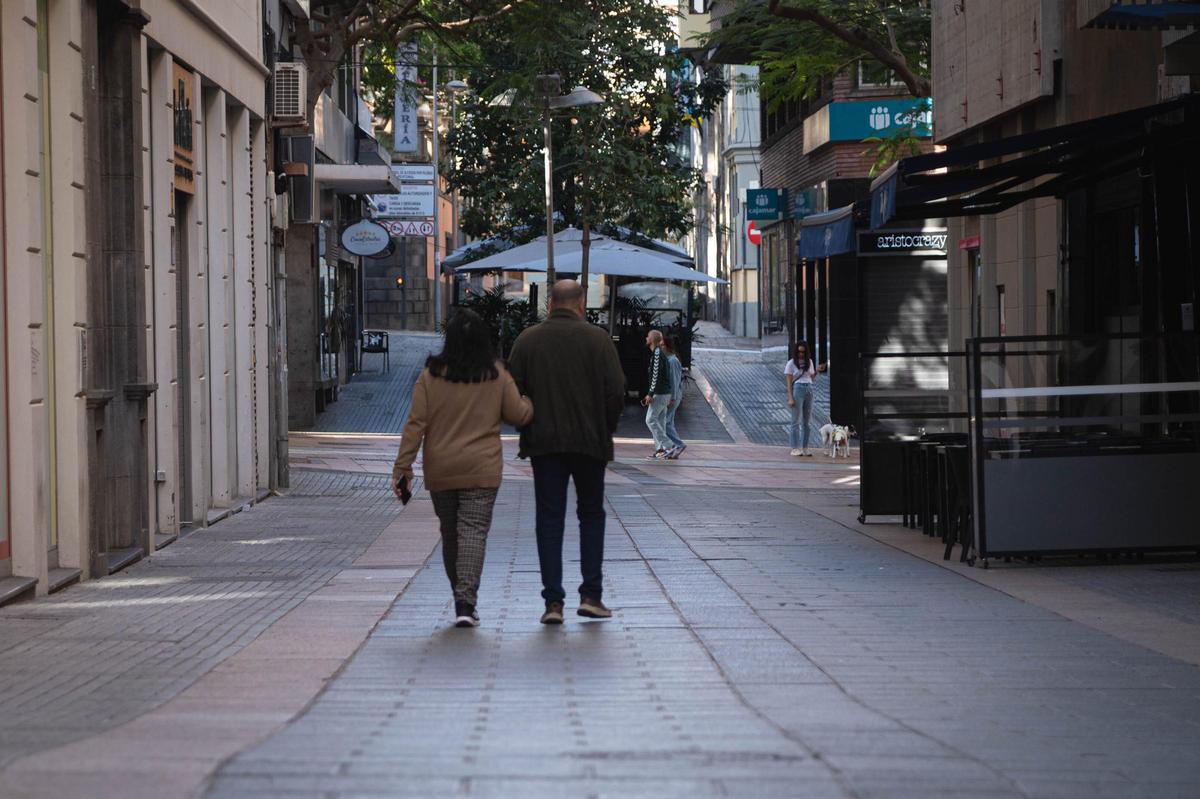 Dos ciudadanos pasean por una calle del centro de Santa Cruz un domingo.