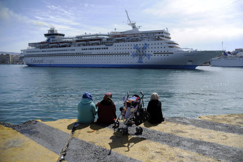 Stranded refugees and migrants watch a cruise ...