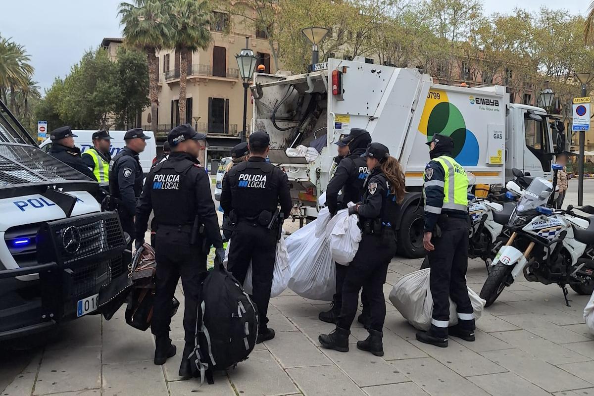 Agentes de Policía, cargados con las bolsas de artículos intervenidos.