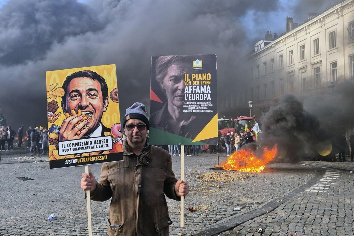 Un manifestante sostiene pancartas de políticos en una protesta de agricultores para denunciar las reformas de la Política Agrícola Común (PAC) y lo que consideran "inaceptables" acuerdos comerciales, en Bruselas, el jueves 18 de diciembre de 2025.
