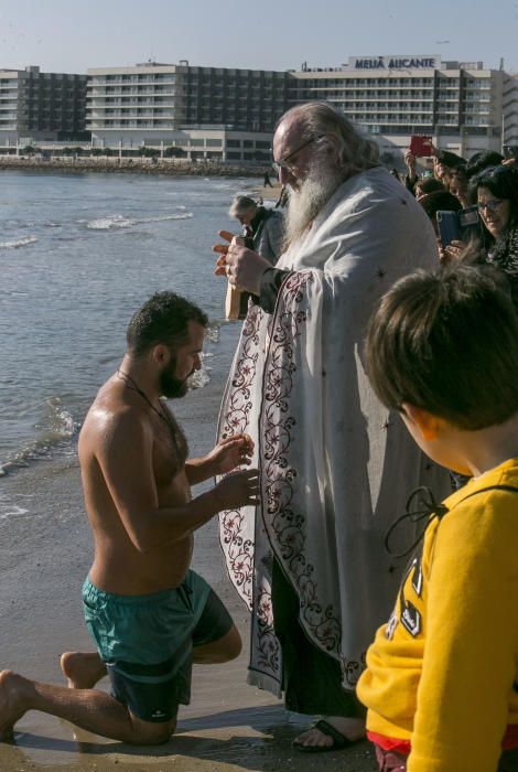 Los ortodoxos celebran en Alicante el bautismo de Jesús con la bendición del mar y con el rito de nadar en busca de la cruz