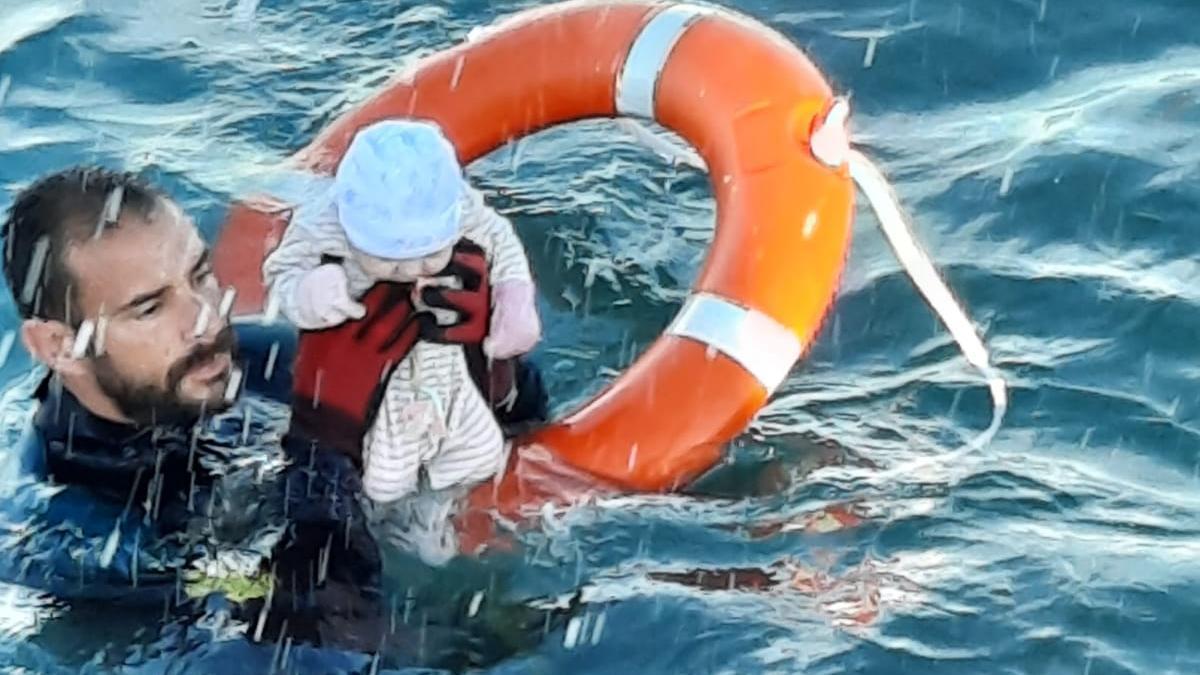 Un guardia givil rescatando a una bebé del mar.