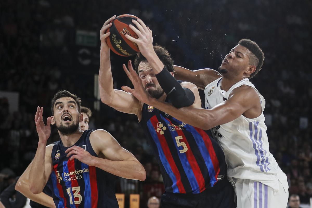 El pívot turco Sertac Sanli, del Barcelona, atrapa el rebote ante el pívot caboverdiano Walter Tavares, del Real Madrid, durante la final de la Supercopa Endesa entre el Real Madrid y el FC Barcelona, disputada en el pabellón de San Pablo de Sevilla. EFE/Jose Manuel Vidal.