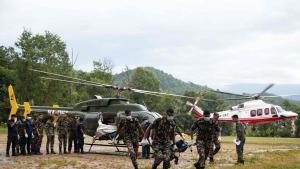 Miembros del Ejército nepalí desembarcan de un helicóptero que transportaba los cuerpos de las víctimas fallecidas durante las operaciones de rescate tras las crecidas repentinas, en el campamento de Trishuli, en el distrito de Nuwakot (Nepal).