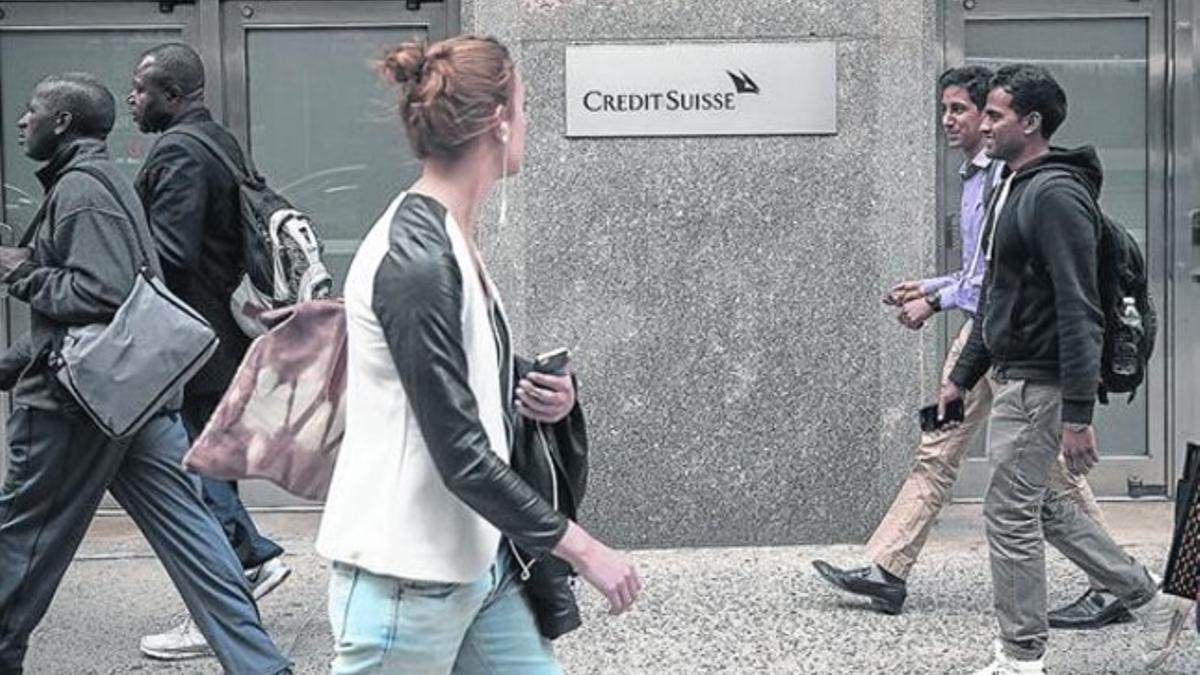 Neoyorkinos pasean frente a un sucursal de Credit Suisse.