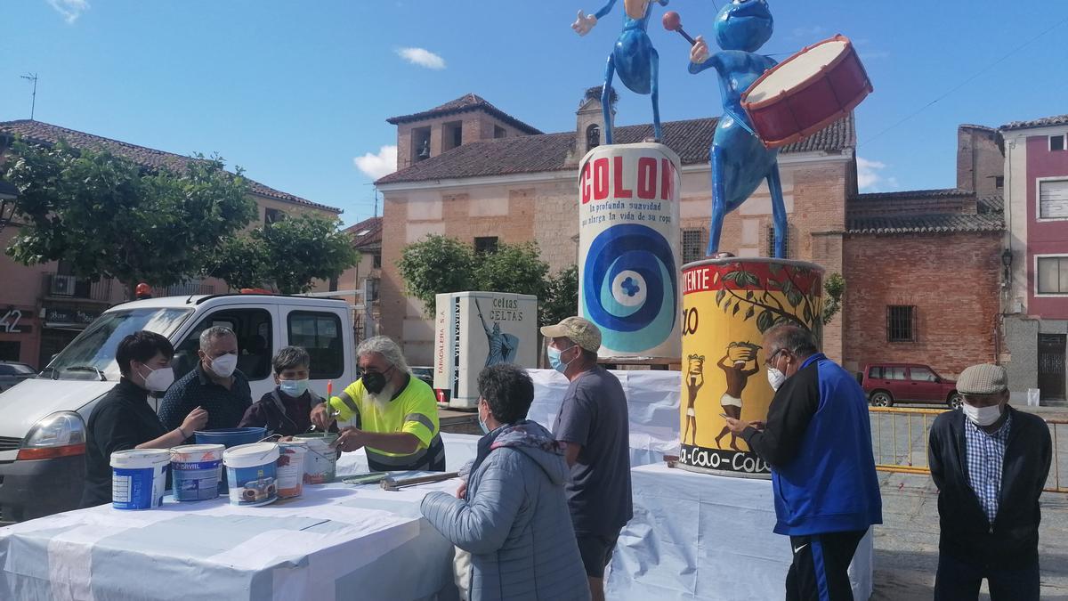 Los socios preparan la pintura para decorar la obra que será prendida en La Glorieta