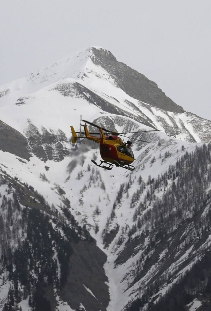 A rescue helicopter from the French Securite Civile flies over the French Alps during a rescue operation near the crash site of an Airbus A320