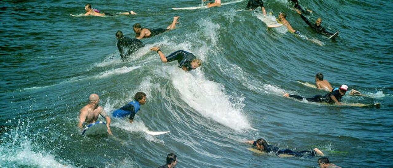 Una multitud de personas practicando surf.