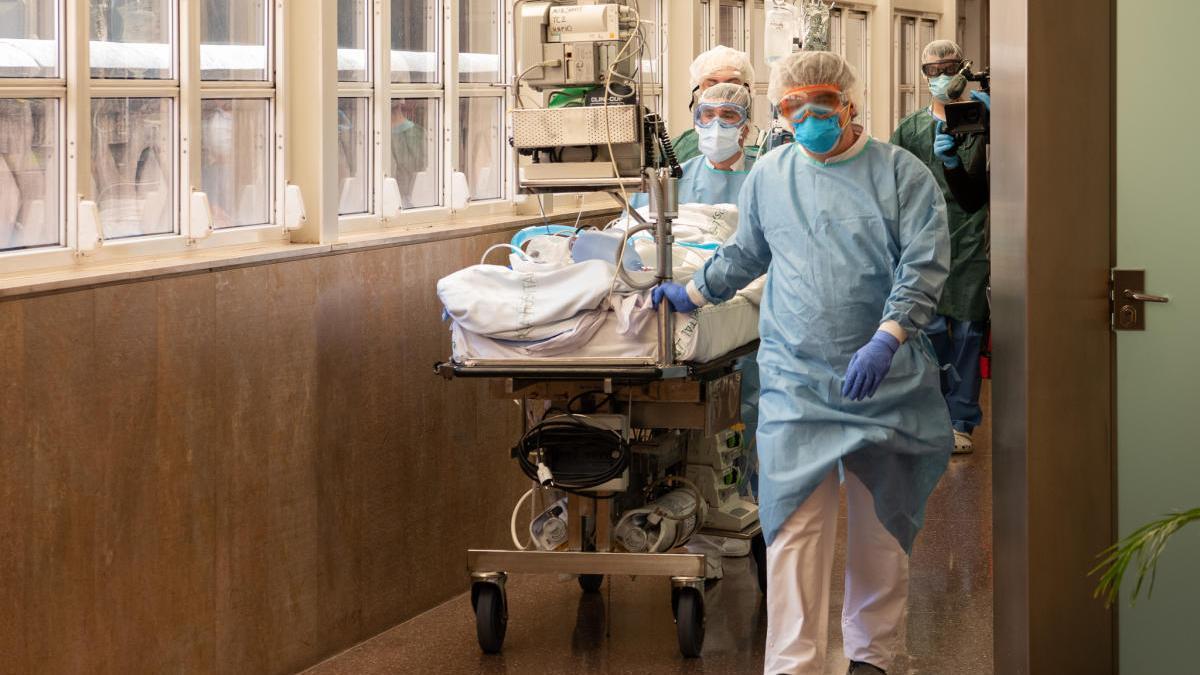 Professionals sanitaris traslladen un pacient de covid-19 per un dels passadissos de l&#039;Hospital Clínic de Barcelona