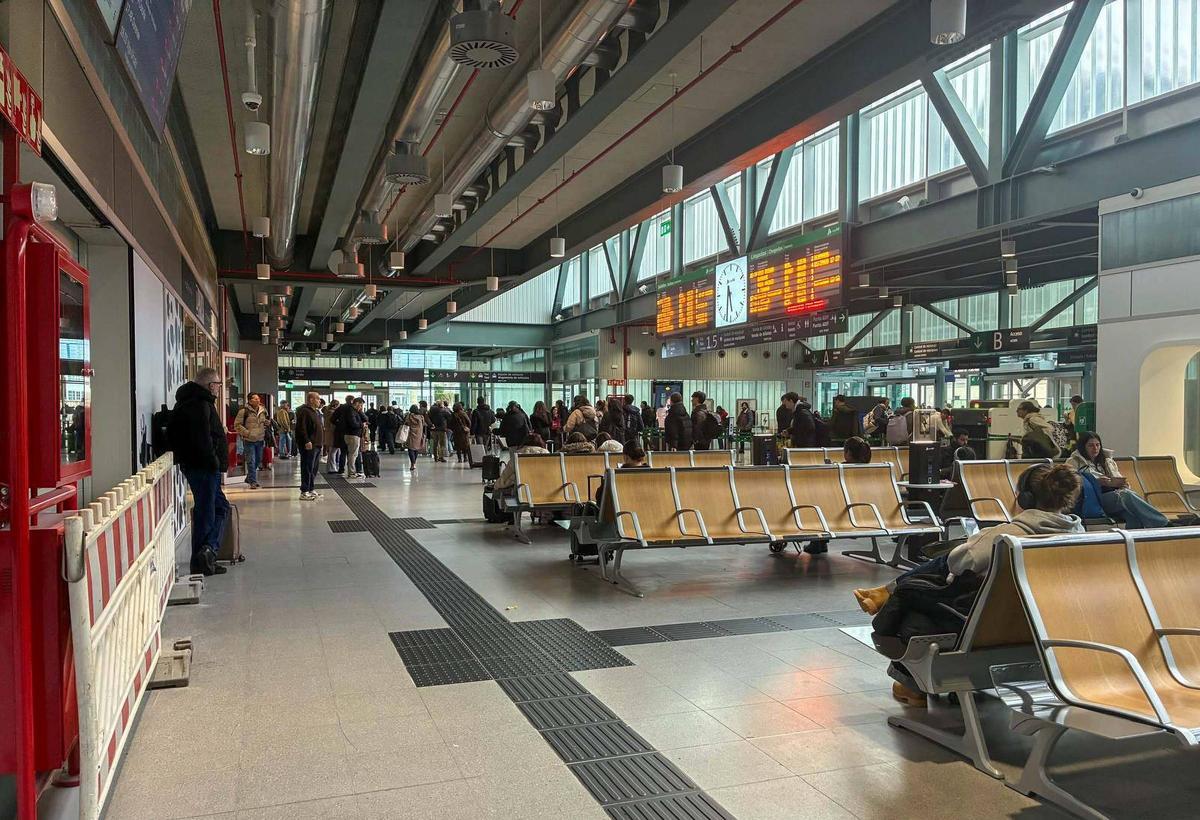 Pasajeros esperando en la terminal de Santiago tras retrasarse sus trenes por incidencias en febrero.
