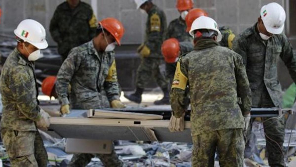 Soldados mexicanos retiran los escombros tras la potente explosión en la sede central de Pemex, este lunes en México.