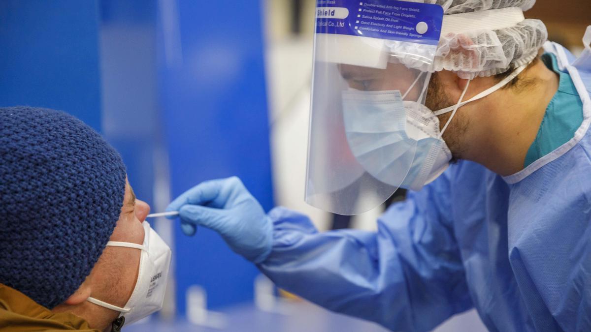 Un sanitario realiza a un hombre una prueba PCR, necesaria para confirmar la baja médica por covid.