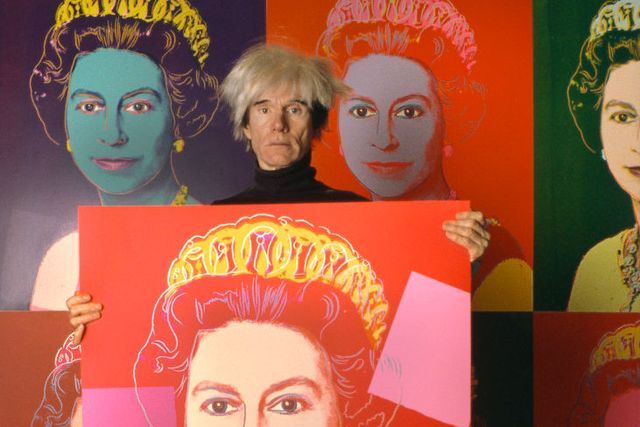 Andy Warhol con algunos de sus retratos de la reina Isabel II.