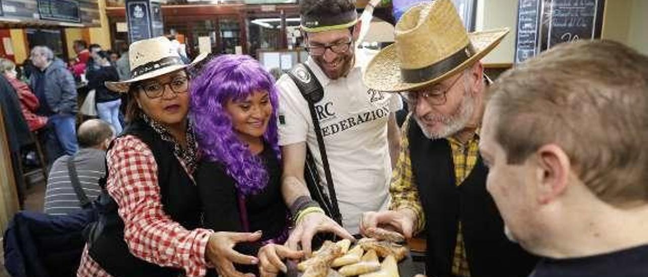 Ulises García ofrece frixuelos y casadielles en la parrilla Antonio a un grupo de comensales anoche.