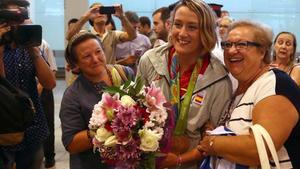 Mireia Belmonte, con sus dos medallas, posa junto a dos vecinas de Badalona, tras su llegada al aeropuerto de El Prat.