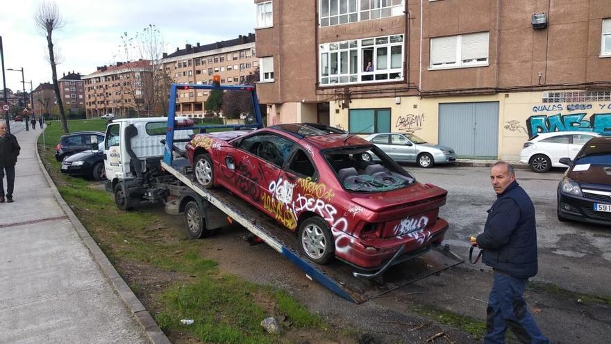 Retiran el coche que llevaba una década abandonado en una parcela cerca del HUCA