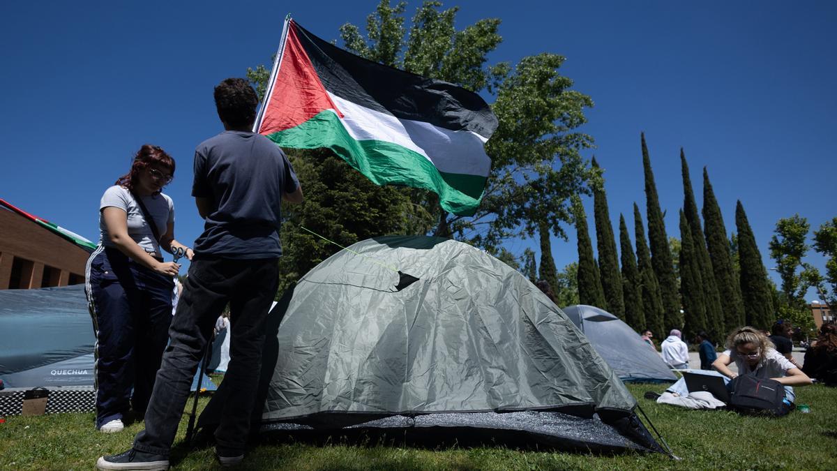 Dos estudiantes con una bandera de Palestina durante una acampada para mostrar su apoyo al pueblo palestino en la Complutense de Madrid