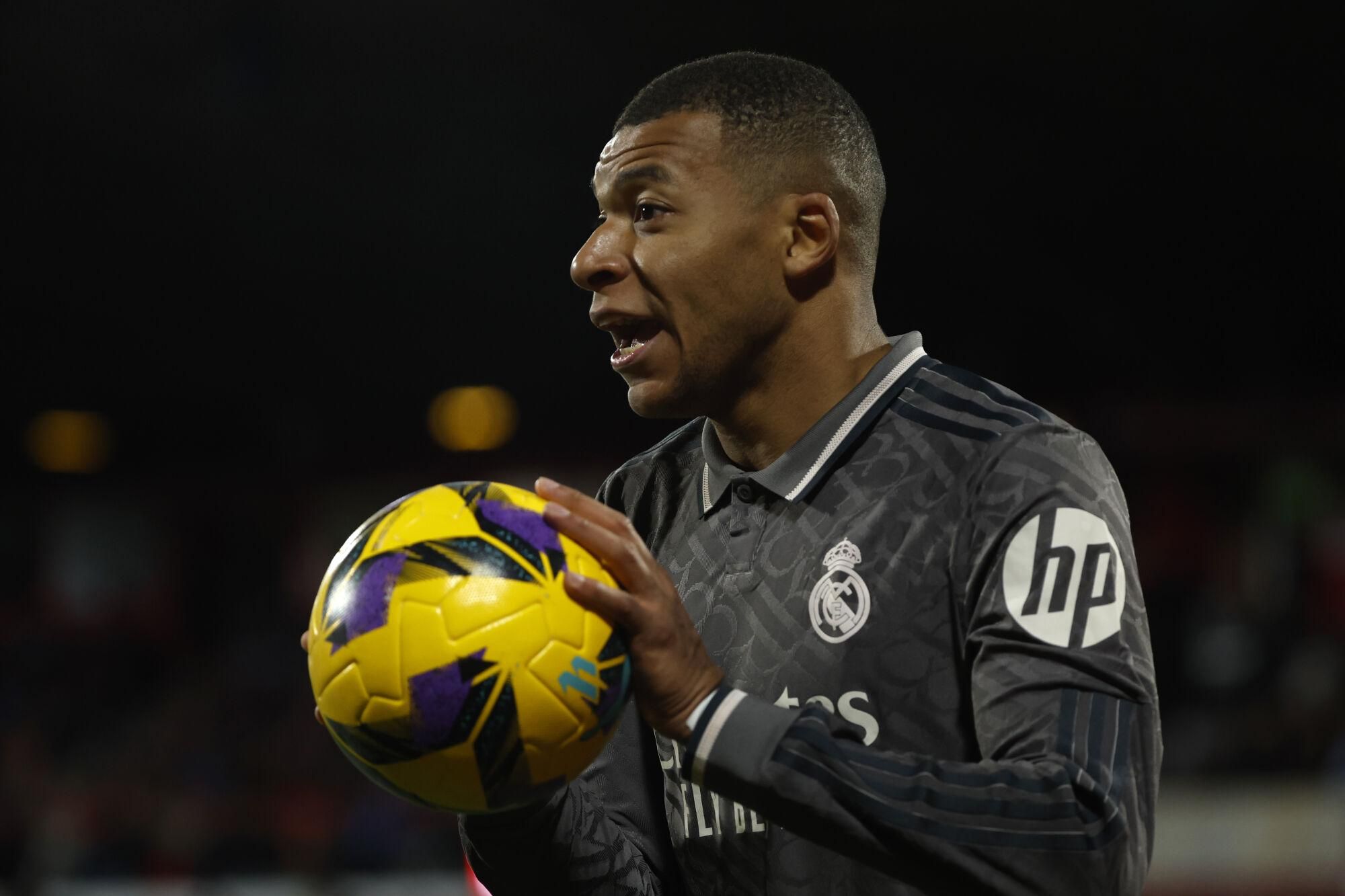Real Madrid's Kylian Mbappe holds the ball during a Spanish La Liga soccer match between Girona and Real Madrid at the Montilivi stadium in Girona, Spain, Saturday, Dec. 7, 2024. (AP Photo/Joan Monfort). EDITORIAL USE ONLY/ONLY ITALY AND SPAIN