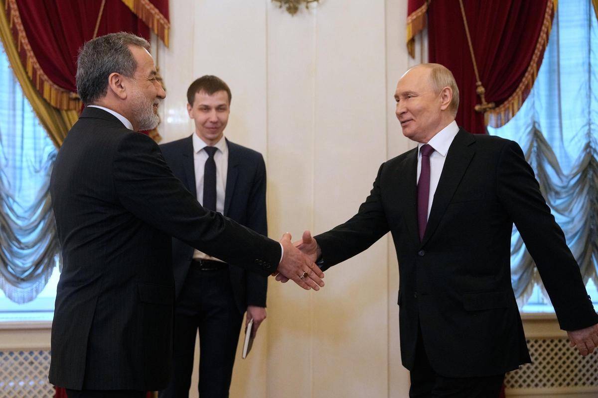 El presidente ruso, Vladímir Putin, saluda al jefe de la diplomacia iraní, Abbas Araghchí, este lunes en San Petersburgo