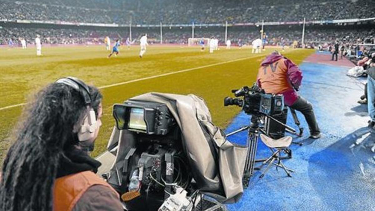 Un cámara de televisión, durante la retransmisión de en un partido del Camp Nou.