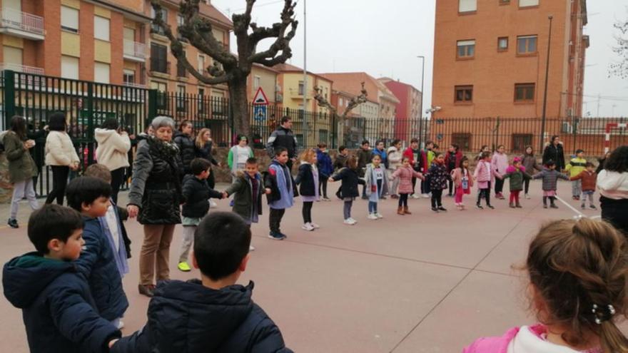 Niños y profesores hacen una cadena humana.