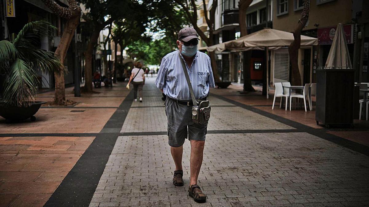 Un hombre con mascarilla pasea por el centro de Santa Cruz de Tenerife.