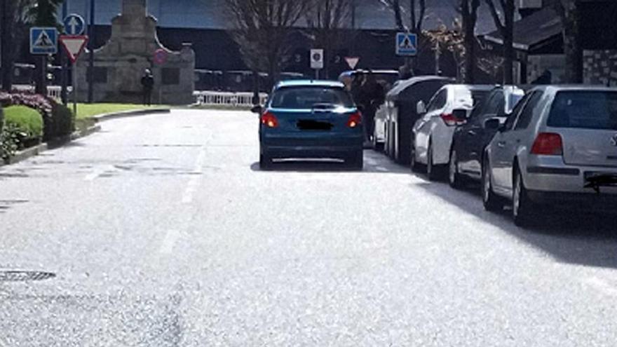 Fotografía del coche aparcado en doble fila cuya denuncia como «ausente» motivó la queja y posterior resolución de la Valedora do Pobo.