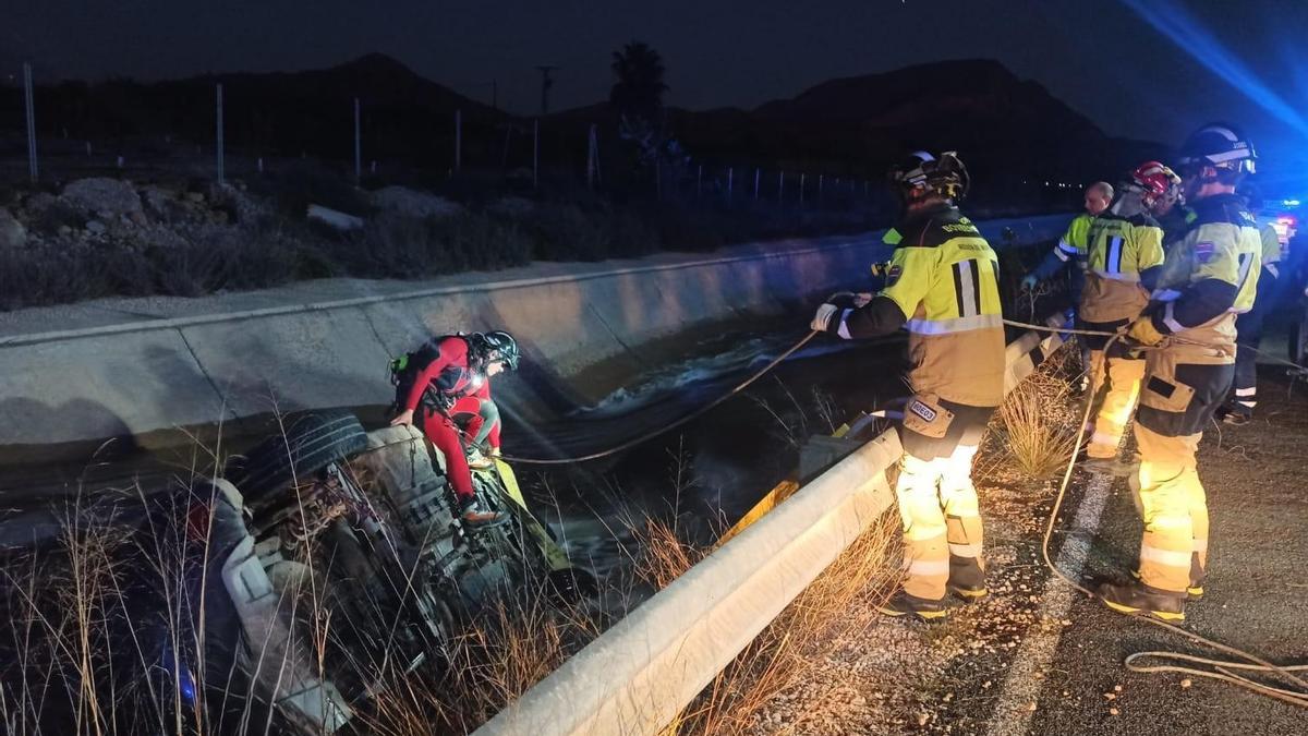 Los efectivos del servicio de emergencias rescatan el vehículo caído.