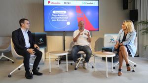 Mesa redonda moderada por la periodista Cristina Buesa organizada por Caixabank sobre la Copa América con Íñigo Roy, director de Estrategia de Comunicación y Patrocinios CaixaBank (con camisa azul y americana) y Nacho Gómez-Zarzuela, periodista especializado en vela y jefe de comunicación del Sail Team BCN (con polo blanco) En la Sala Gregal del Moll de Gregal del Port Olímpic