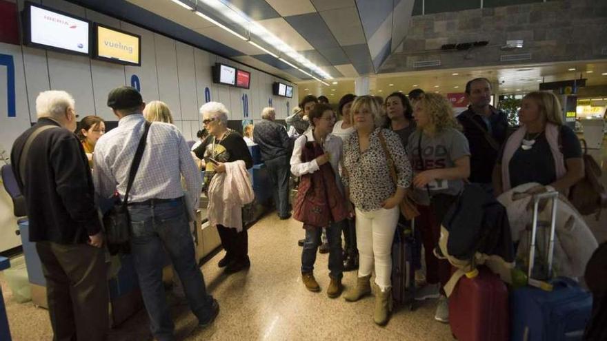 Imagen de los viajeros expulsados de su vuelo ayer en la terminal de Alvedro. 13fotos