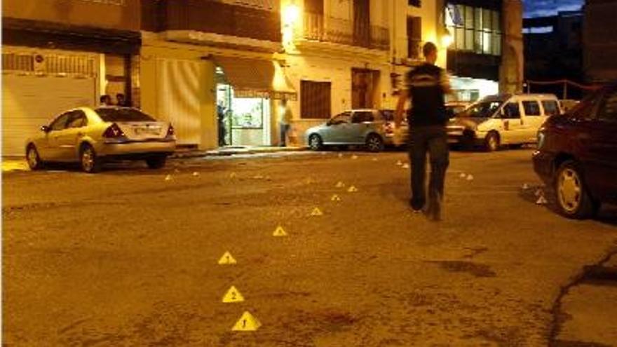 Un agente recorre el reguero de sangre tras ser acotado con testigos de plástico.