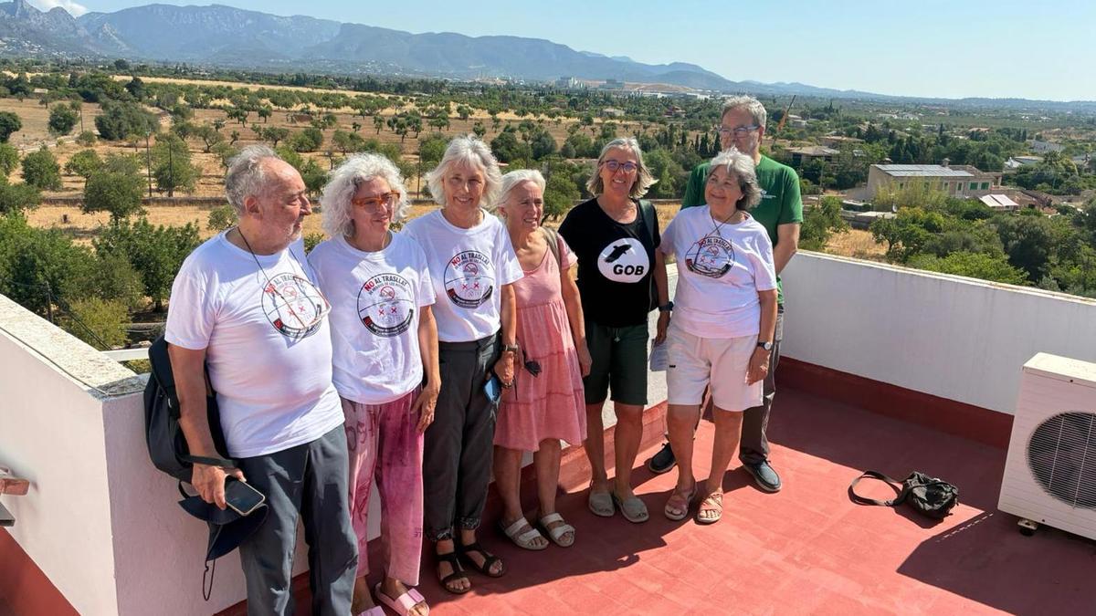Representantes del frente común posan con la incineradora de Son Reus de fondo, ataviados con camisetas con lemas contra el traslado.