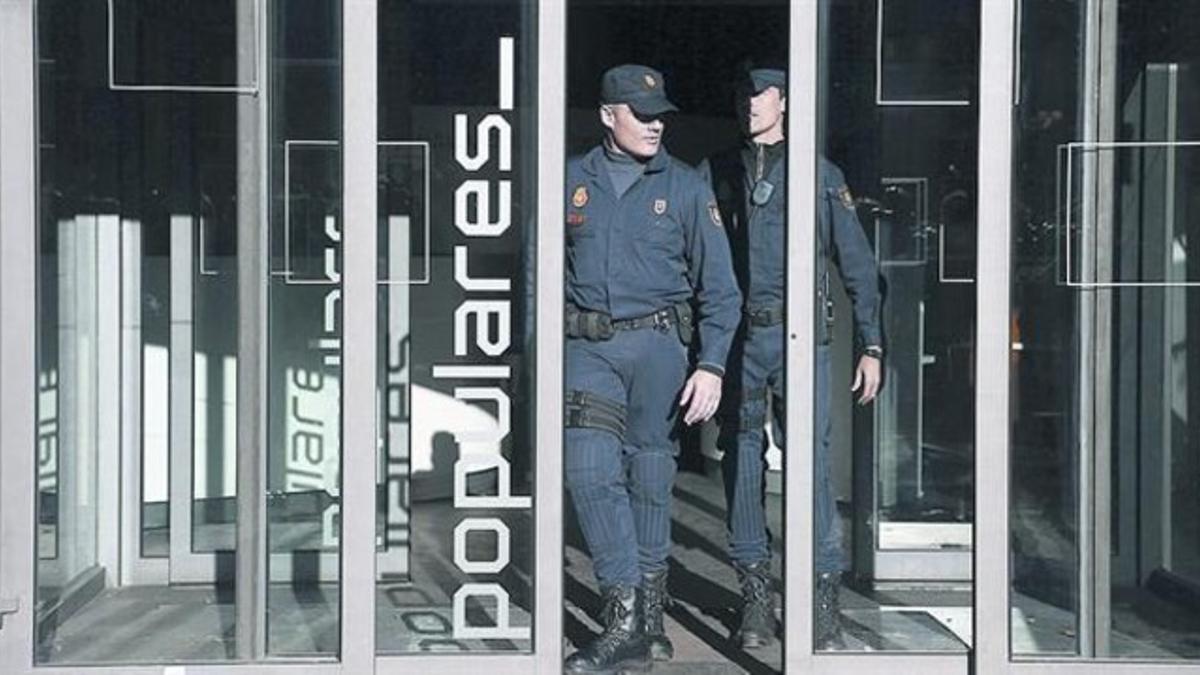 Agentes de la Policía Nacional durante el registro a la sede del PP, el pasado jueves.