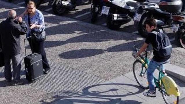Un ciclista, a punt de pujar a una vorera, en una imatge d'arxiu.