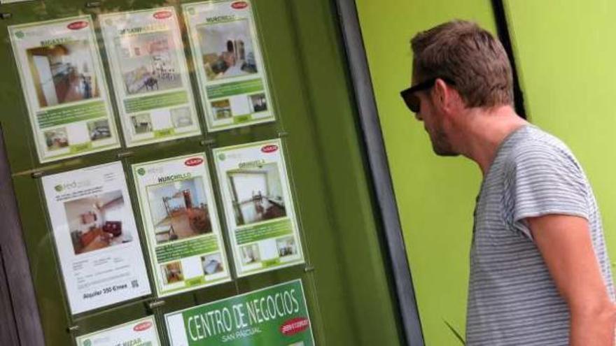 Una imagen de archivo de clientes frente a la sede de una agencia inmobiliaria de la Vega Baja.