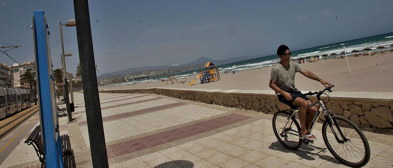 Un ciclista circula por el paseo de la playa de Muchavista pese a las señales que lo prohíben, en una imagen de archivo. |