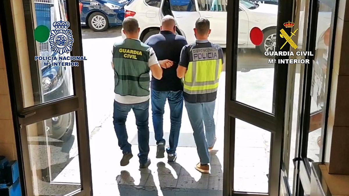 Agentes de la Policía Nacional y la Guardia Civil trasladan a Santiago Fuentes desde la Comisaría de Tres de Mayo. | | E.D.